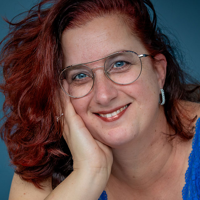 Glimlachend model met rood haar kijkt in de camera