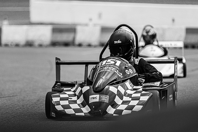Zwart-witfoto van twee greenracing-karts op een racecircuit