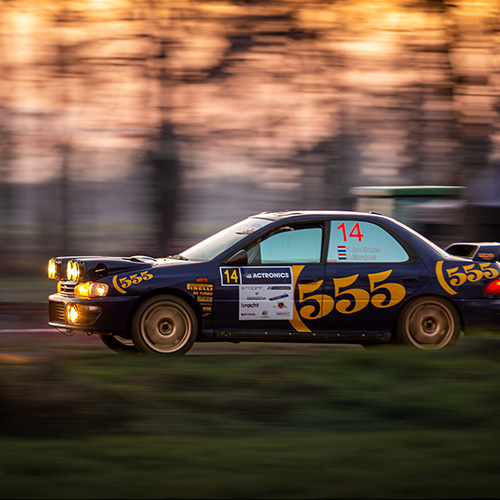 555 Impreza rijdt in de avond een klassementsproef van de Berkelland Rally