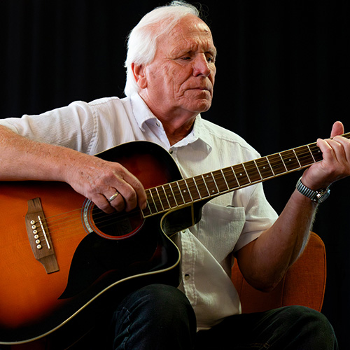 Arie speelt gitaar tijens het verhalenboekje MuzeMobiel