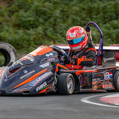 Een kart van het kampioens-team Hub van Doornecollege rijdt in de bocht van een racecircuit